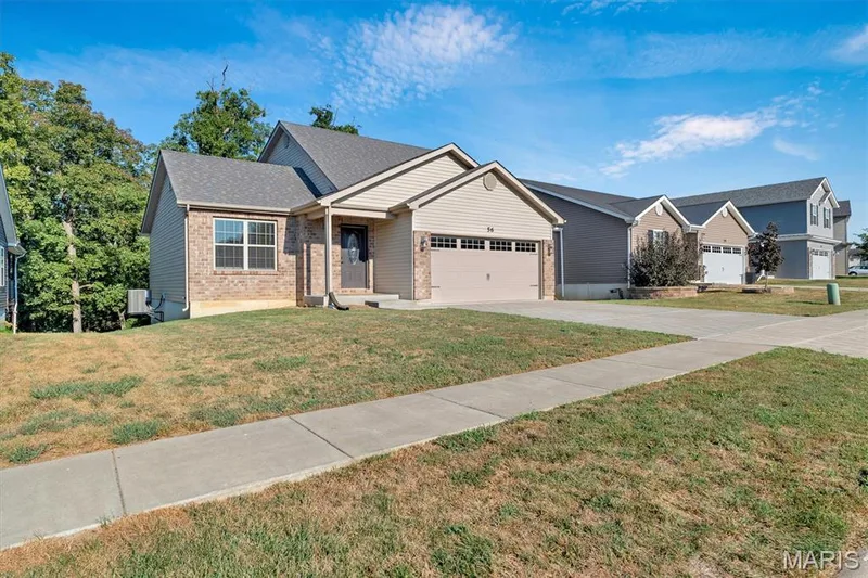 Exterior featuring a blend of brick and siding, an attached two-car garage, and a covered front entry — 56 Huntleigh Park Court, Wentzville, MO 63385