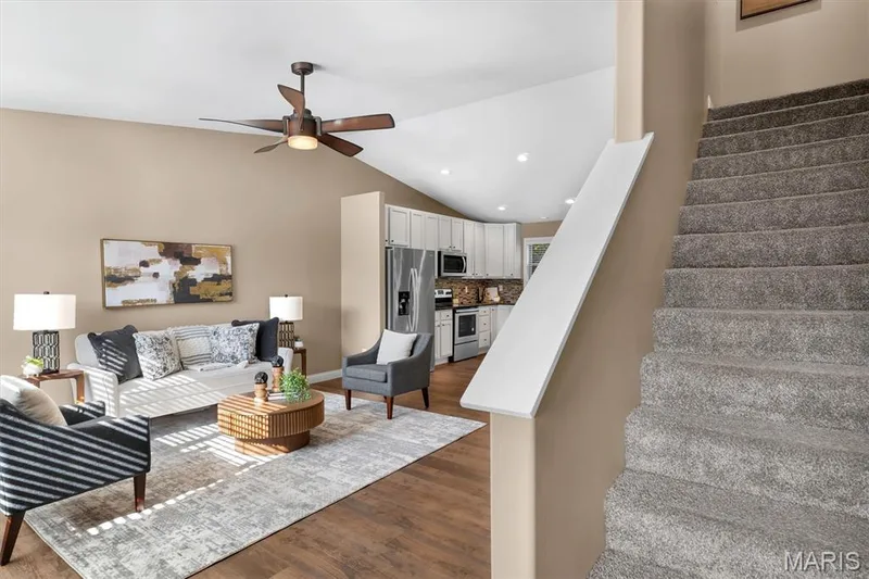 Vaulted ceiling with a ceiling fan, wood-finish flooring, recessed lighting, white cabinetry, and stainless steel appliances — 56 Huntleigh Park Court, Wentzville, MO 63385
