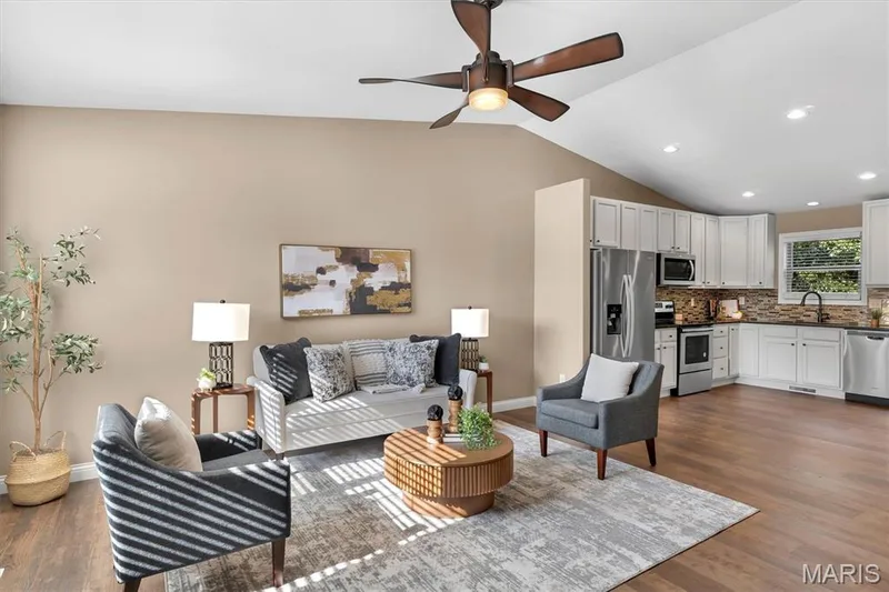 Vaulted ceiling, wood-finish flooring, white cabinetry, stainless steel appliances, and a ceiling fan with integrated lighting — 56 Huntleigh Park Court, Wentzville, MO 63385