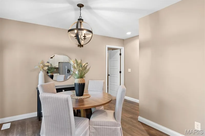 Wood-finish flooring, recessed lighting, and a modern globe chandelier — 56 Huntleigh Park Court, Wentzville, MO 63385