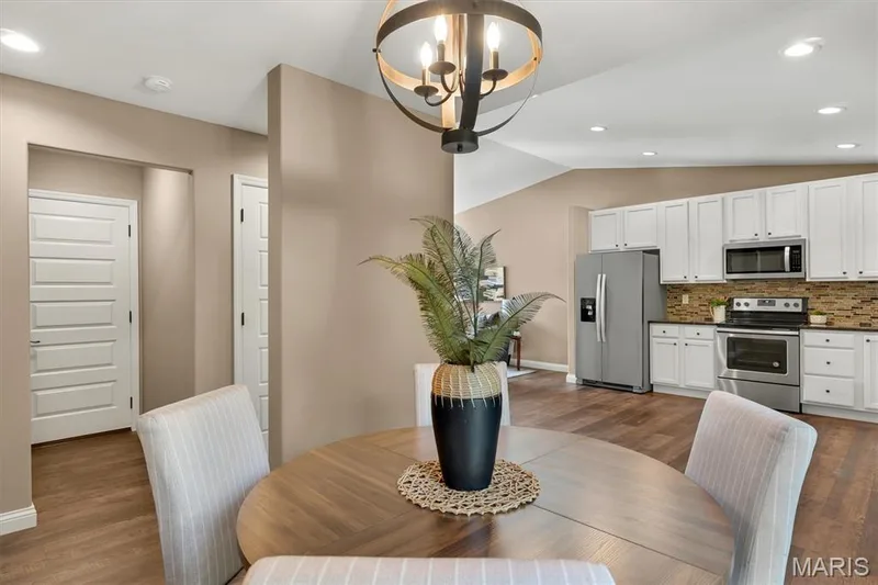 Open-concept kitchen with white cabinetry and stainless steel appliances — 56 Huntleigh Park Court, Wentzville, MO 63385