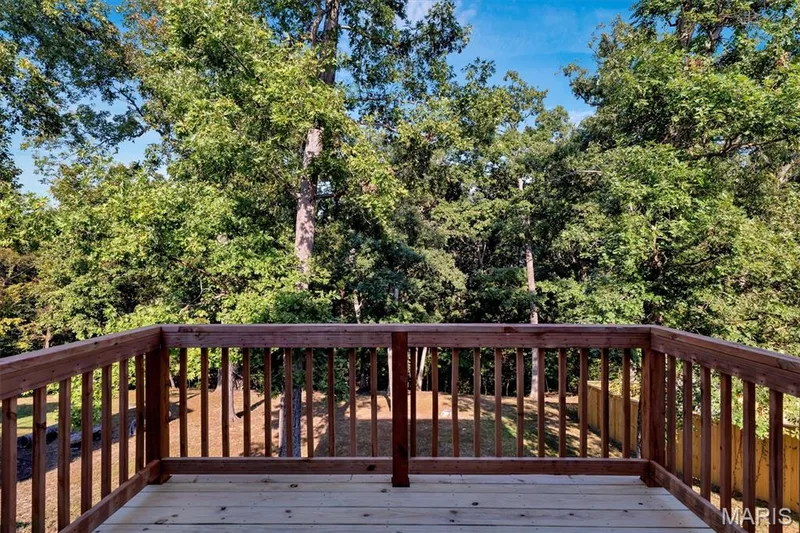 Wood deck with a natural finish, wood railing, and a backdrop of mature trees — 56 Huntleigh Park Court, Wentzville, MO 63385