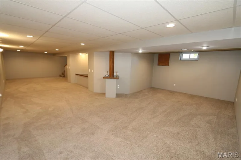 View from far corner. Expansive carpeted area with recessed lighting, drop ceiling, and a built-in wood-finish shelf — 3 Oxbow Road, St Peters, MO 63376