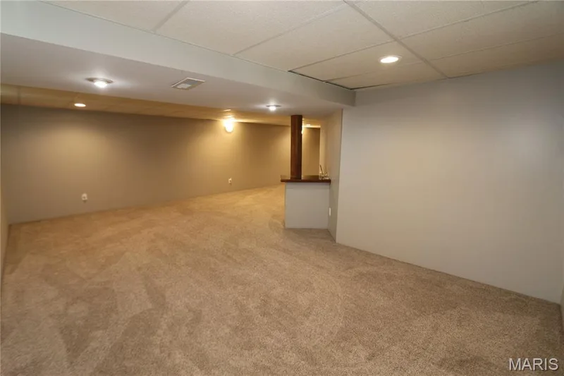 Tucked away area for more privacy if needed. Expansive carpeted area with recessed lighting and a built-in counter surface with a wood-finish column — 3 Oxbow Road, St Peters, MO 63376