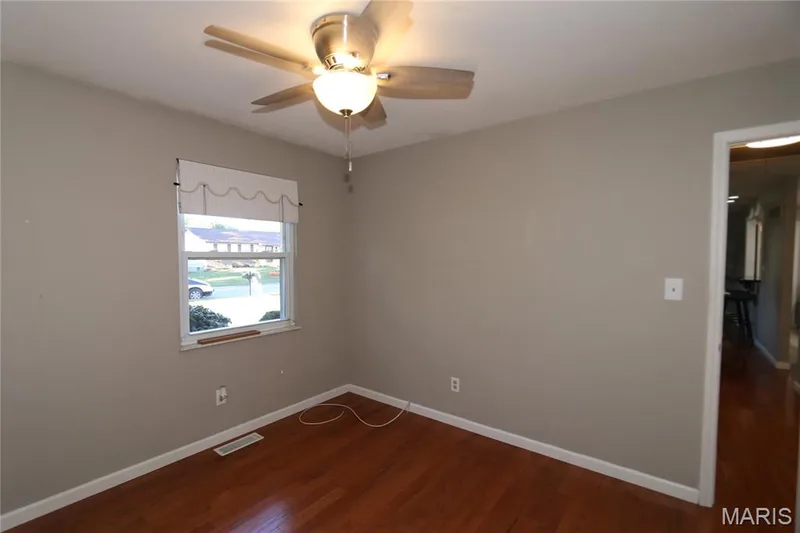 #2 Bedroom - view from closet corner. Wood-finish flooring with a ceiling fan light fixture and neutral wall color — 3 Oxbow Road, St Peters, MO 63376