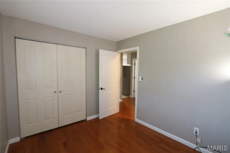 #3 Bedroom - view from front corner showing closet & entrance to the room. Wood-finish flooring with white baseboards — 3 Oxbow Road, St Peters, MO 63376