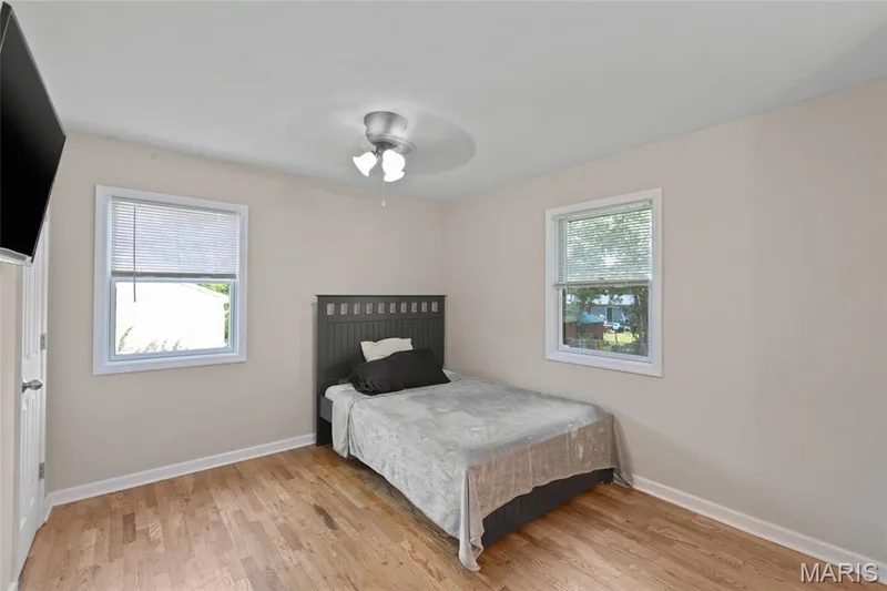 Hardwood flooring throughout, two windows with blinds, and a ceiling-mounted light fixture — 712 Highland Drive, O'Fallon, MO 63366