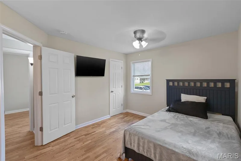 Wood-finish flooring, ceiling fan with integrated lighting, wall-mounted display, and white interior doors — 712 Highland Drive, O'Fallon, MO 63366