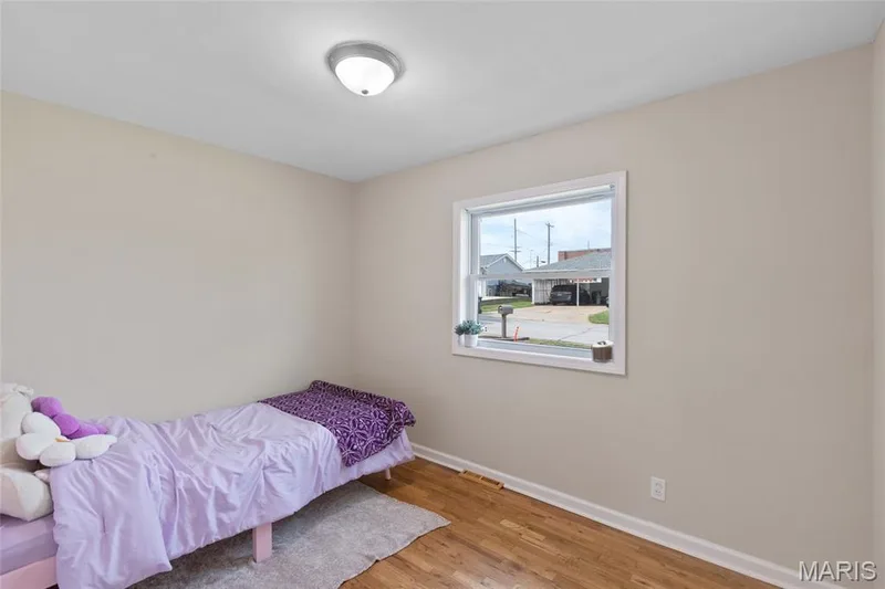 Hardwood flooring, neutral wall tones, white trim, and a flush mount ceiling light — 712 Highland Drive, O'Fallon, MO 63366