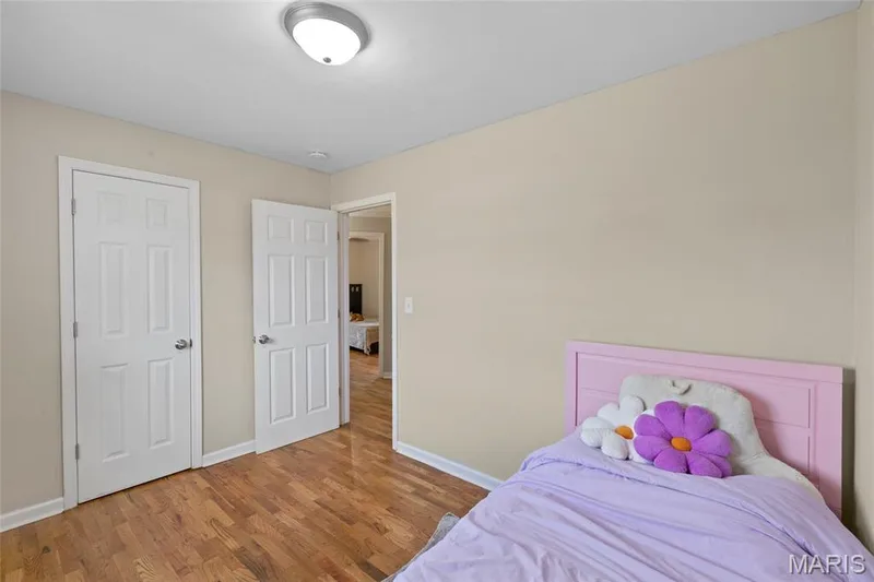 Wood-finish flooring with neutral wall paint, white trim, and a flush-mount ceiling light fixture — 712 Highland Drive, O'Fallon, MO 63366