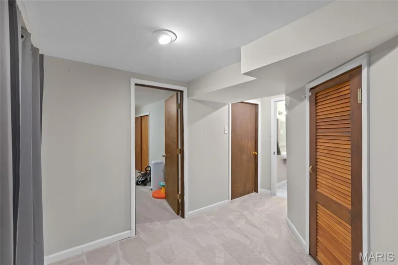 Plush carpet flooring, recessed ceiling lighting, and multiple wood-panel doors — 712 Highland Drive, O'Fallon, MO 63366