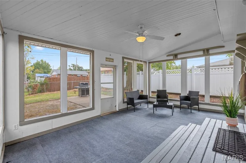 Enclosed sunroom with vaulted ceiling, ceiling fan, and multiple windows — 712 Highland Drive, O'Fallon, MO 63366