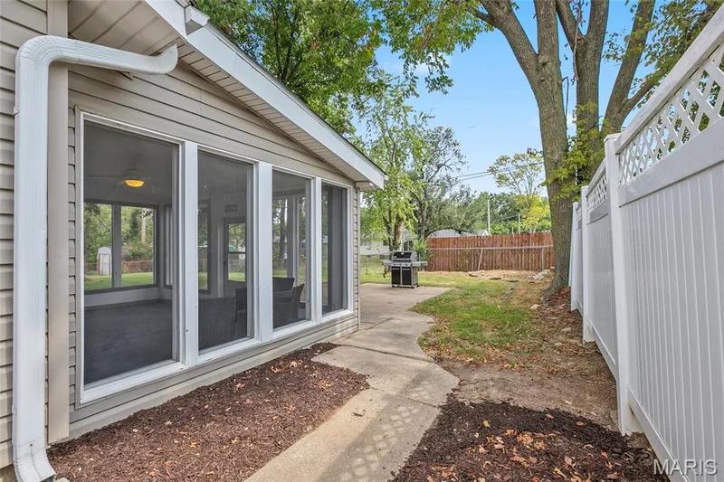 Screened-in porch with multiple windows, leading to an exterior concrete path — 712 Highland Drive, O'Fallon, MO 63366