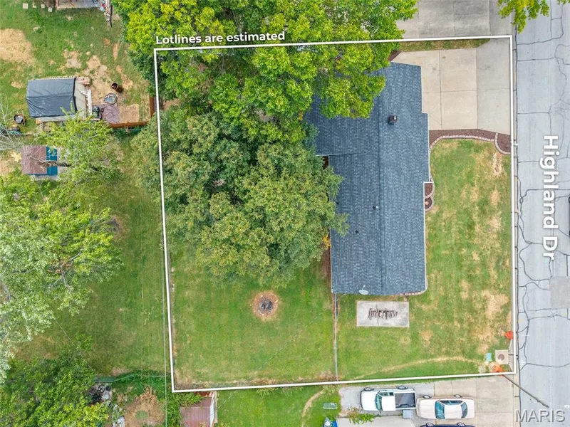 Expansive lot featuring mature trees, a substantial lawn area, concrete driveway, and direct street access — 712 Highland Drive, O'Fallon, MO 63366