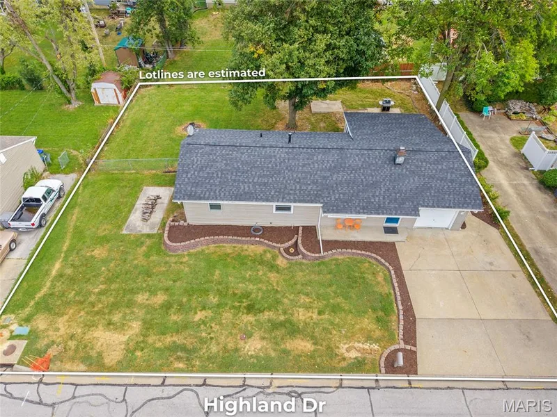 Paved driveway, attached garage, front yard landscaping, mature trees, and a storage shed — 712 Highland Drive, O'Fallon, MO 63366