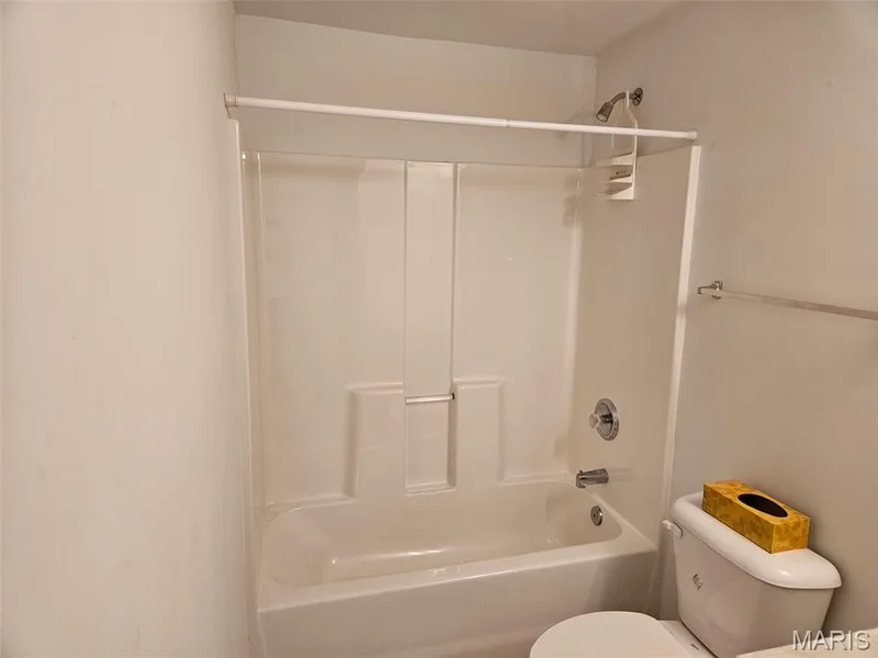 Bathtub with an integrated shower, chrome fixtures, and a white toilet — 1129 Piepers Glen Lane #8A, O'Fallon, MO 63366