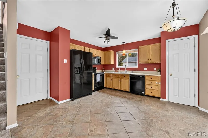 The garage is just off the kitchen behind the white door on the left. — 1033 Providence Pointe Drive, Wentzville, MO 63385
