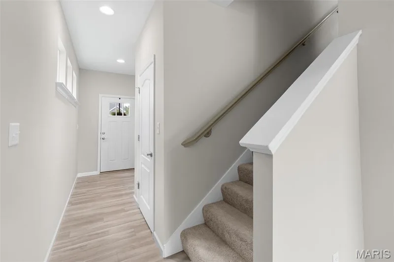 Entryway featuring a white paneled door with glass inserts, wood-finish flooring, and recessed lighting — 17 Rydal Place, St Charles, MO 63303