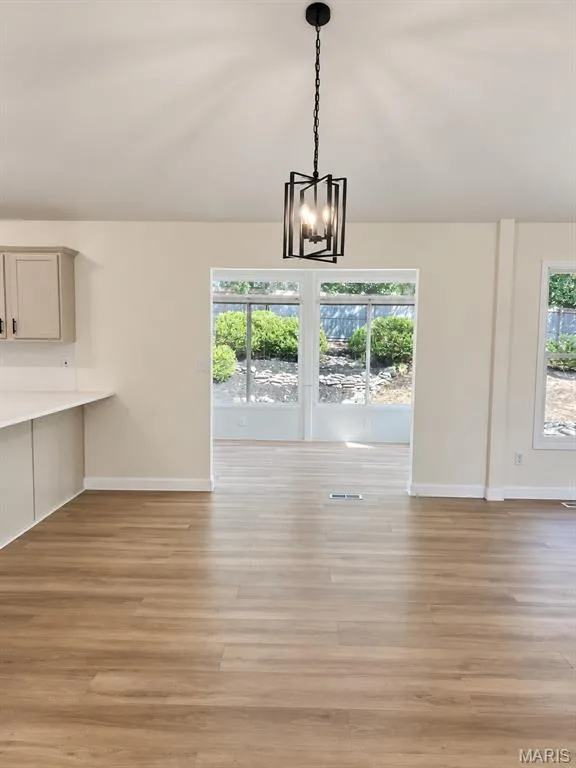 Recessed lighting, wood-finish flooring, white walls, and a black geometric pendant light — 1731 Fairview Farms Circle, Wentzville, MO 63385