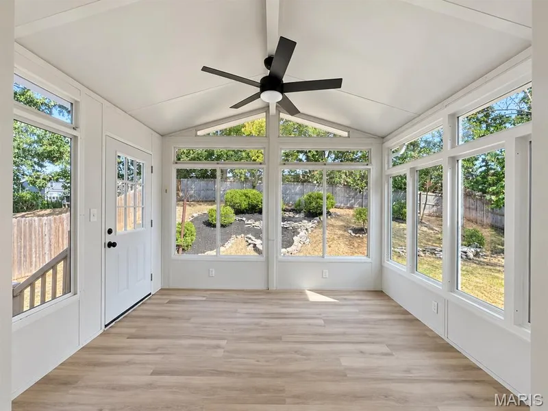 Sunroom featuring a vaulted ceiling, multiple windows, wood-finish flooring, and a ceiling fan — 1731 Fairview Farms Circle, Wentzville, MO 63385