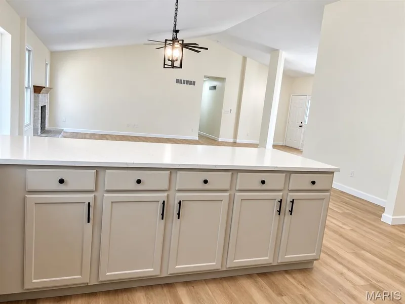 Kitchen island with light-toned cabinetry, a white countertop, and black hardware — 1731 Fairview Farms Circle, Wentzville, MO 63385