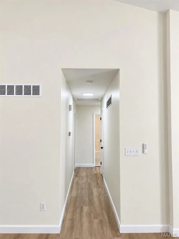 Hallway featuring wood-finish flooring, white trim, and recessed lighting — 1731 Fairview Farms Circle, Wentzville, MO 63385