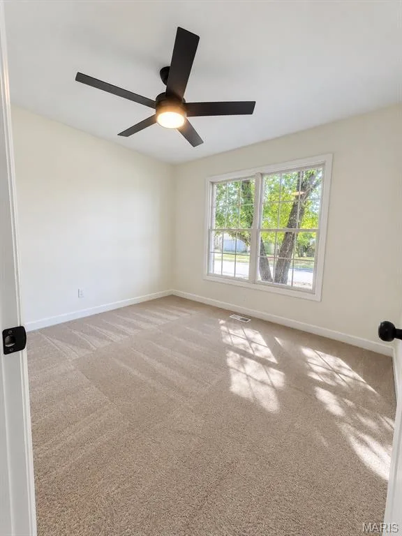 Neutral tone wall paint, carpeted flooring, double-paned window, and a ceiling fan with integrated lighting — 1731 Fairview Farms Circle, Wentzville, MO 63385