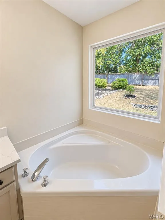 Corner soaking tub with chrome fixtures and a window with outdoor landscaping — 1731 Fairview Farms Circle, Wentzville, MO 63385