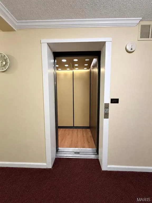 Elevator entry with wood-finish flooring and recessed lighting — 15631 Hedgeford Court #9, Chesterfield, MO 63017