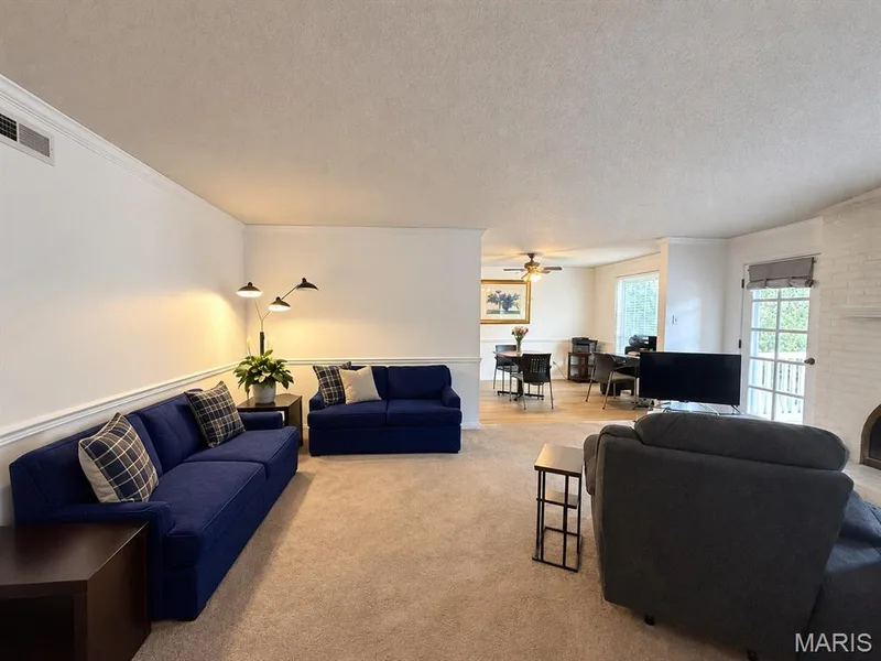 Spacious living area with neutral carpeting and crown molding — 15631 Hedgeford Court #9, Chesterfield, MO 63017