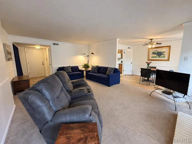 Carpeted living area,  white paneled doors, ceiling fan, and crown molding — 15631 Hedgeford Court #9, Chesterfield, MO 63017