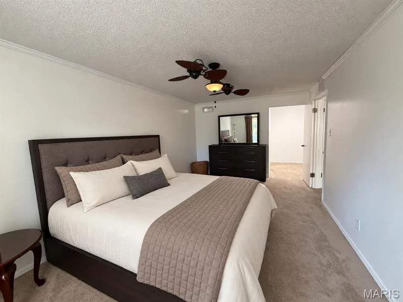 Neutral tone walls with crown molding, textured ceiling, and carpeted flooring — 15631 Hedgeford Court #9, Chesterfield, MO 63017