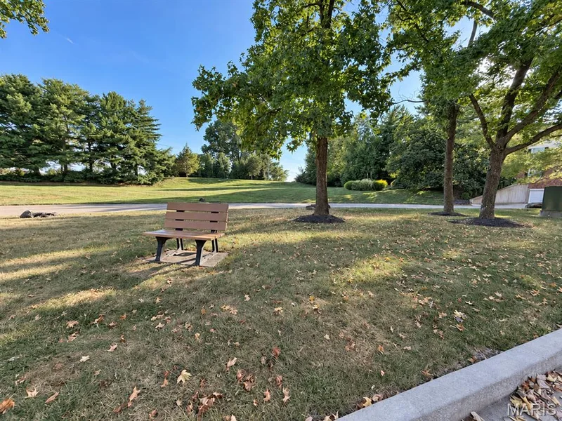 Expansive green space featuring mature trees and a park bench — 15631 Hedgeford Court #9, Chesterfield, MO 63017