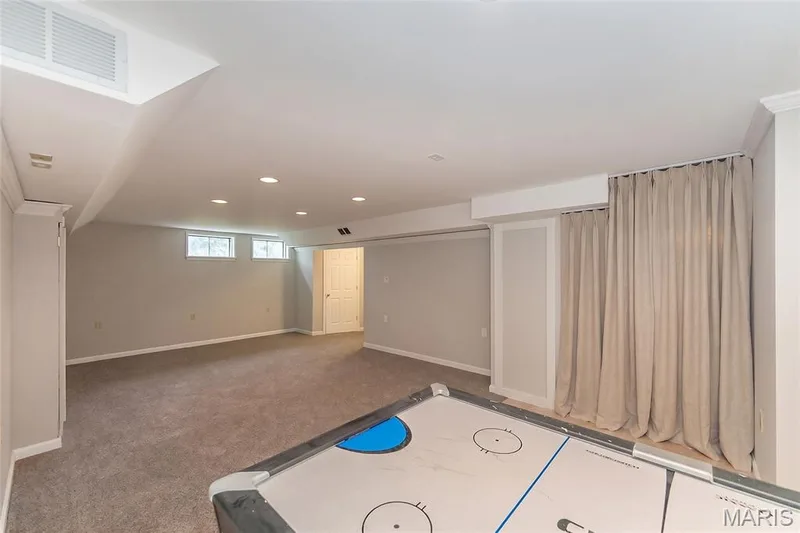 Lower Level Rec room. (Curtain added with AI) — 472 Brookhaven Court, O'Fallon, MO 63368