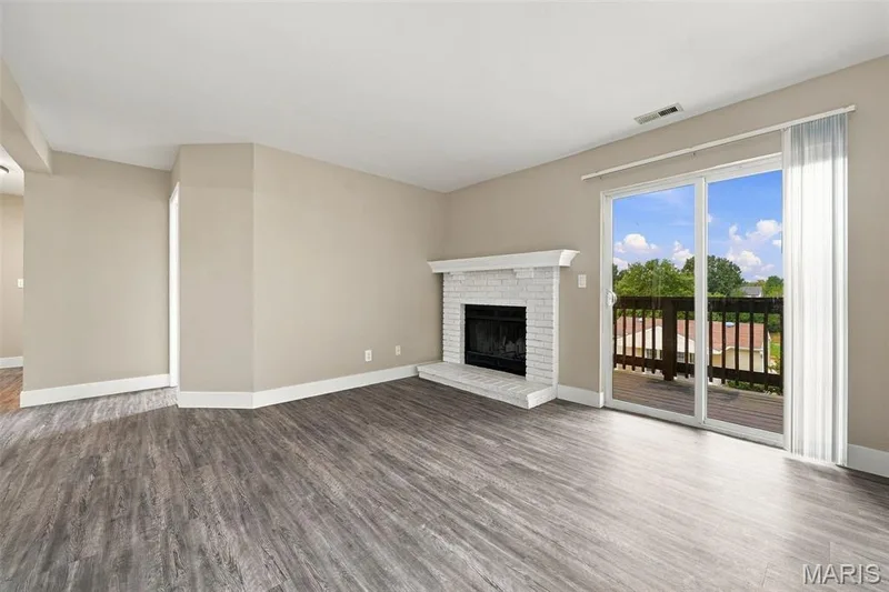 Spacious living room with wood burning fireplace and sliding door with access to deck. — 2415 Sandalwood Creek Court #C, Wildwood, MO 63038