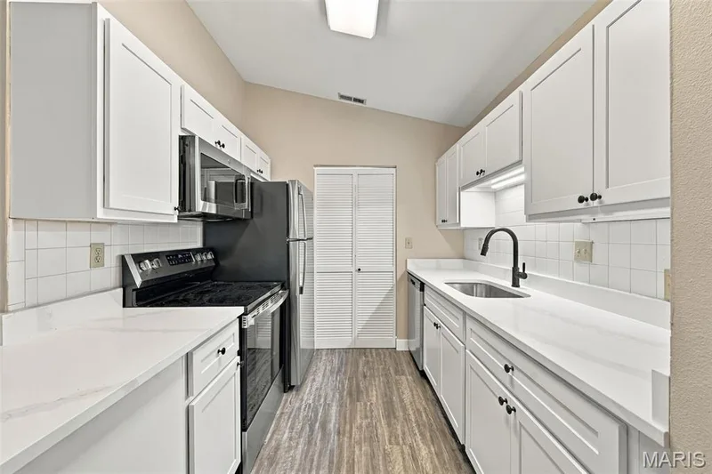 Kitchen with vaulted ceiling boasts all new cabinetry, new granite counter tops, and new stainless steel appliance. — 2415 Sandalwood Creek Court #E, Wildwood, MO 63038