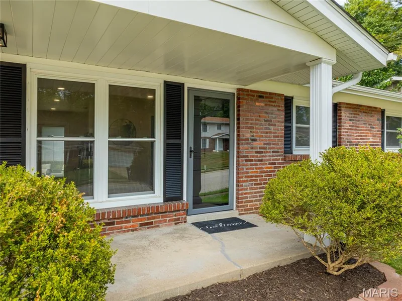Brick exterior with white trim, covered front entry, and concrete walkway — 3025 Sherwood Lane, St Charles, MO 63301