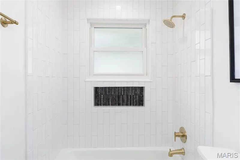 Bathtub-shower combination with vertical white subway tile surround — 3025 Sherwood Lane, St Charles, MO 63301