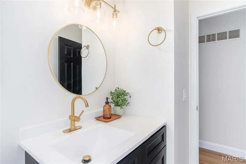 Vanity with a white countertop and integrated sink, accented by a gold-finish faucet — 3025 Sherwood Lane, St Charles, MO 63301