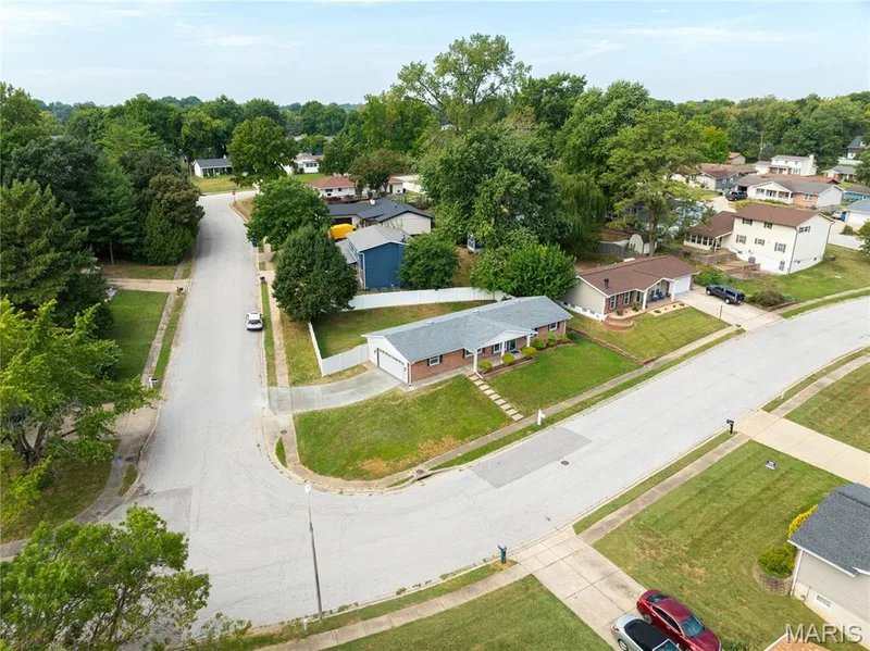 Brick-front residence with an attached garage, situated on a corner lot with mature landscaping — 3025 Sherwood Lane, St Charles, MO 63301