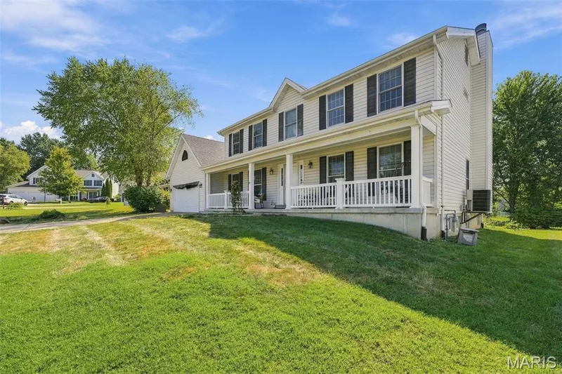Two-story residence with a covered front porch, white siding, and black window shutters — 8 Jacobs Place Court, O'Fallon, MO 63376