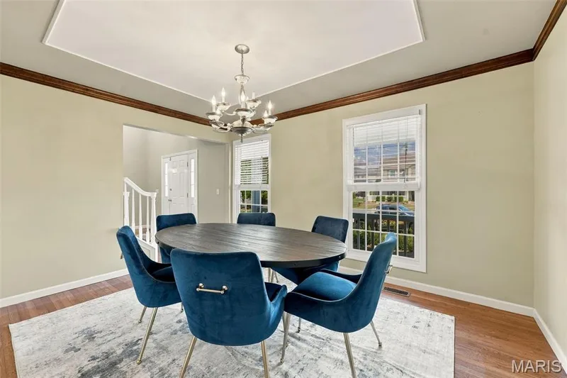 Tray ceiling featuring a contemporary chandelier, hardwood flooring, and crown molding — 8 Jacobs Place Court, O'Fallon, MO 63376