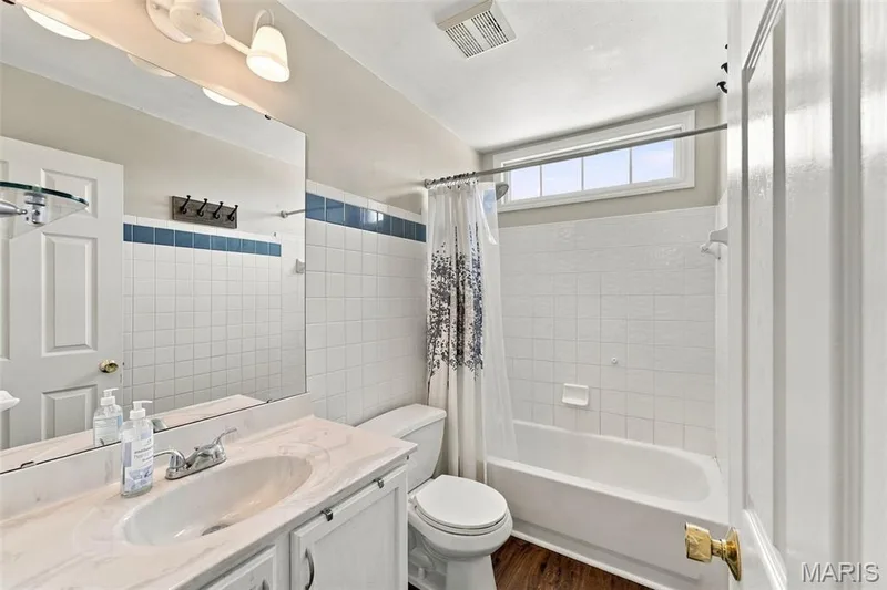 Bathroom featuring a single vanity with an integrated sink, polished chrome faucet, and a large wall-mounted mirror — 8 Jacobs Place Court, O'Fallon, MO 63376