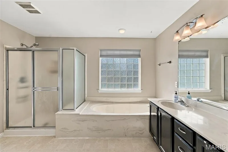 Dual vanity with undermount sinks, integrated countertop, and substantial mirror — 8 Jacobs Place Court, O'Fallon, MO 63376