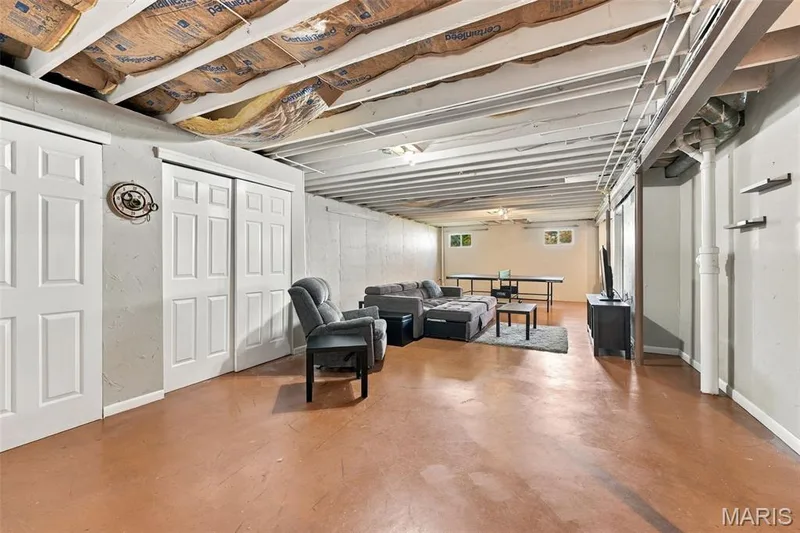 Expansive open-concept basement with light-toned walls, exposed ceiling joists, and multiple entry points — 8 Jacobs Place Court, O'Fallon, MO 63376
