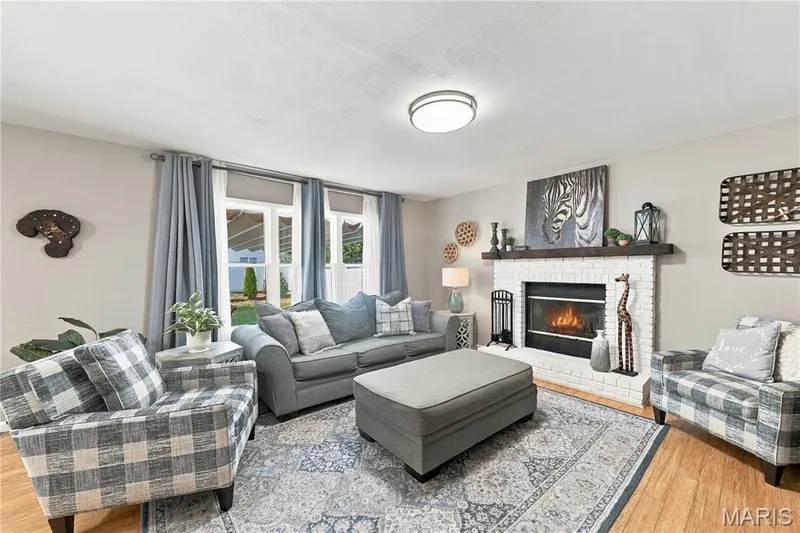 Updated double hung windows, ceiling light and raised hearth wood burning fireplace with wood mantle. — 1417 Plantation Manor Court, St Peters, MO 63303