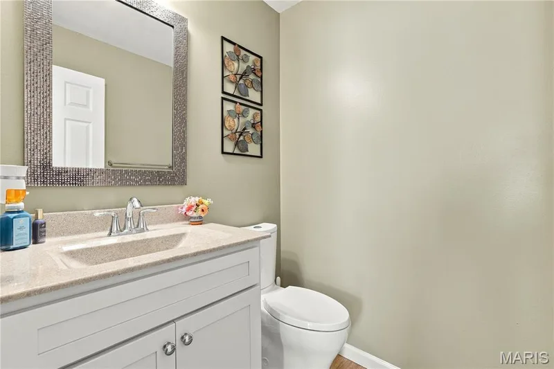 White vanity, integrated vanity sink and neutral decor. — 1417 Plantation Manor Court, St Peters, MO 63303