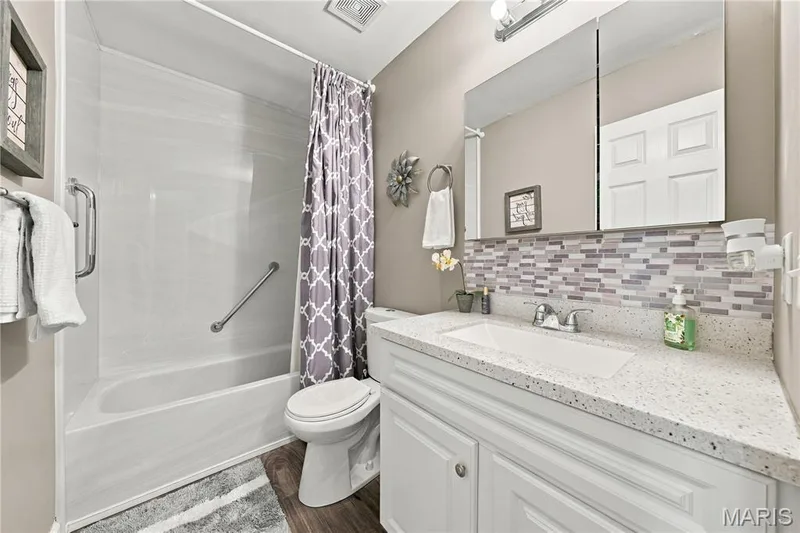 Luxury vinyl plank flooring, white vanity with integral bowl, medicine cabinet and neutral decor. — 1417 Plantation Manor Court, St Peters, MO 63303