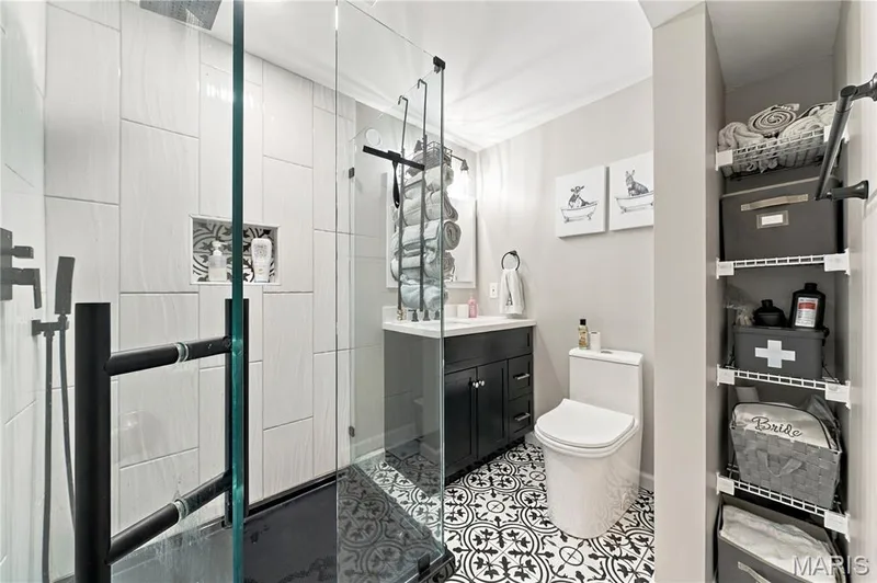 Gorgeous bath, ceramic tile flooring, glass enclosed shower, vanity with drawers and shelving space. — 1417 Plantation Manor Court, St Peters, MO 63303