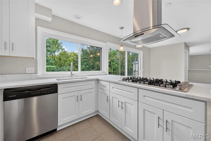 Fully renovated kitchen with new white shaker cabinetry, new stainless steel gas cooktop, stainless steel range hood, and new white marble countertops. — 231 Renaldo Drive, Chesterfield, MO 63017